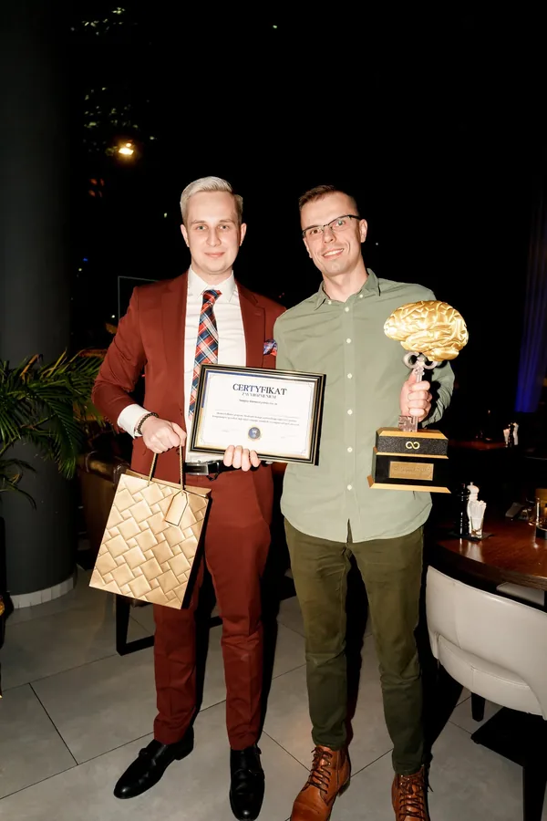 Oskar Litwin wręcza certyfikat z wyróżnieniem i statuetkę absolwentowi Akademii
